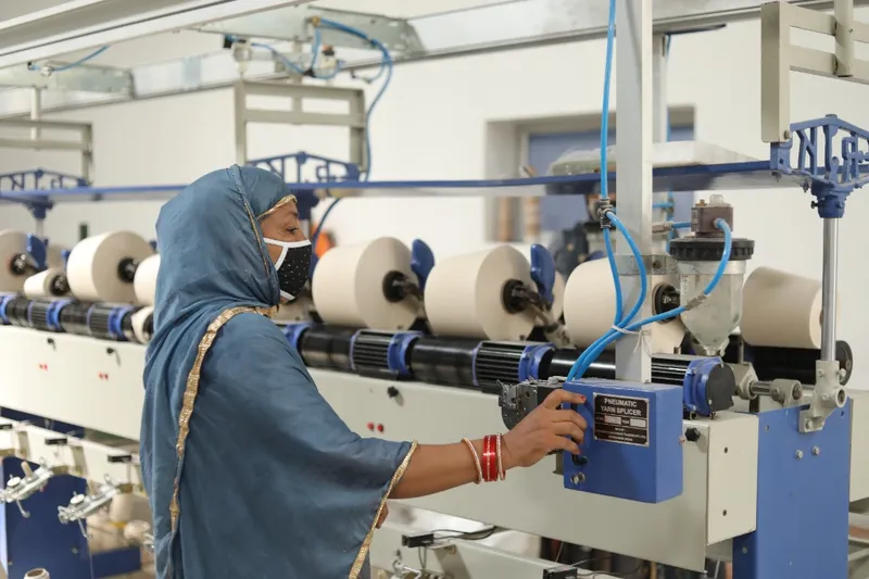 Indian woman operator with pneumatic yarn splicer